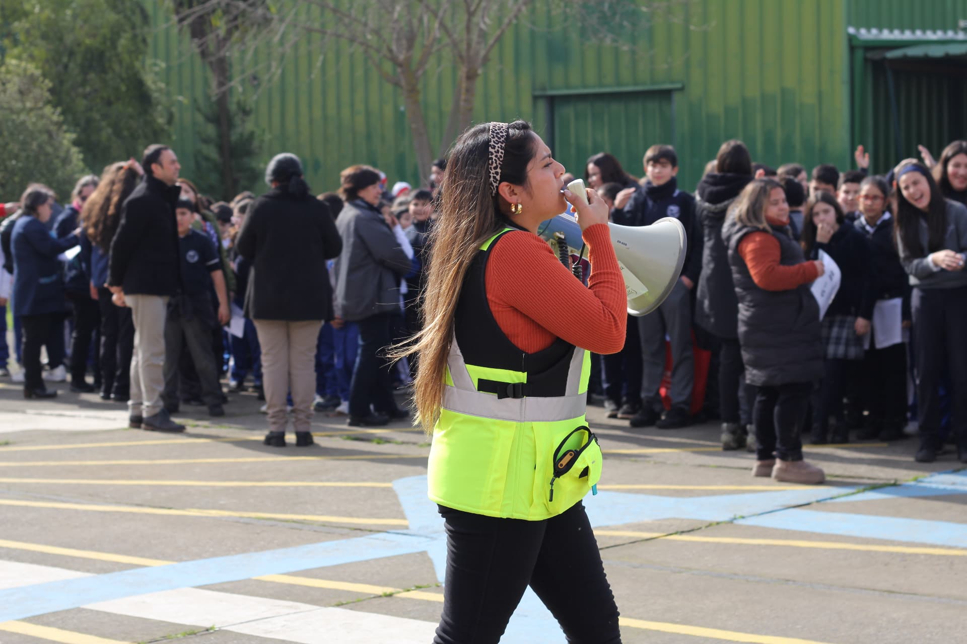 Dominique guiando una evacuación con megáfono en el patio